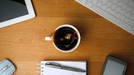 sugar cubes falling into cup of coffee and splashing a tablet pc