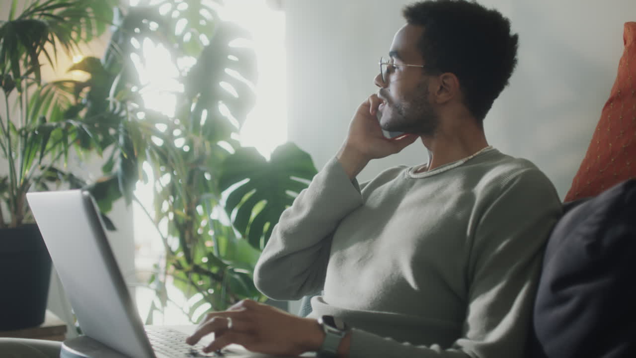 Freelancer che usa laptop e cellulare a casa