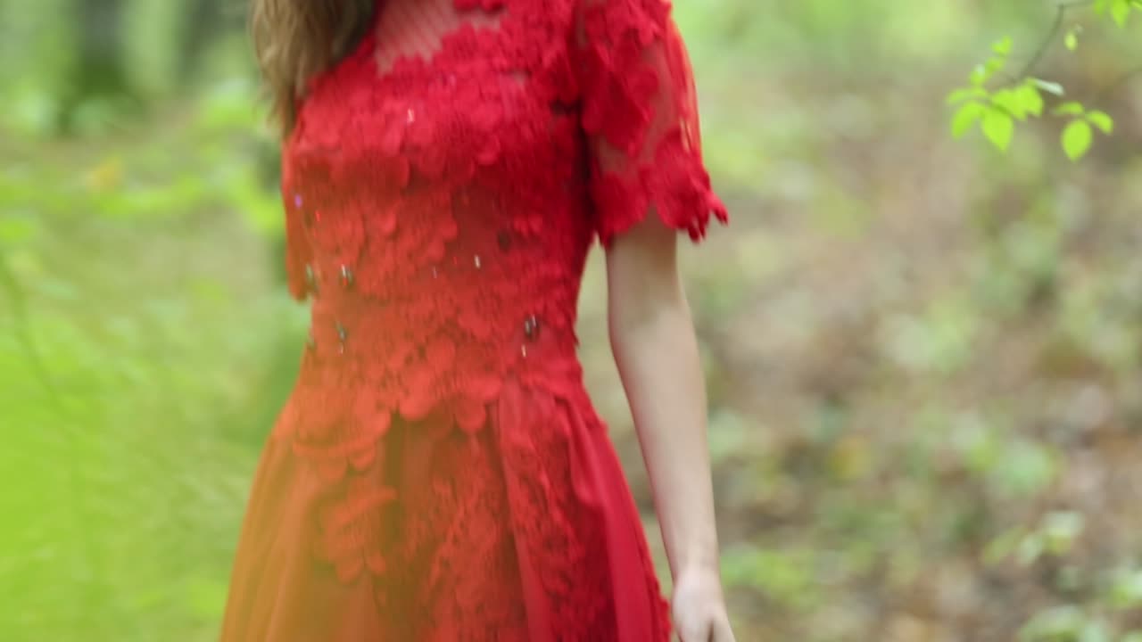 Beautiful Girl Walking In Forest. Beautiful girl in red long dress walking in forest