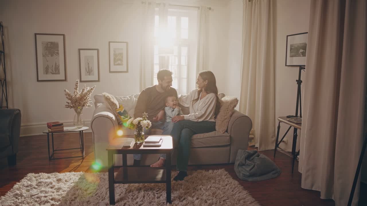 A warm, intimate family moment unfolds in a cozy living room, captured in a soft, sunlit video
