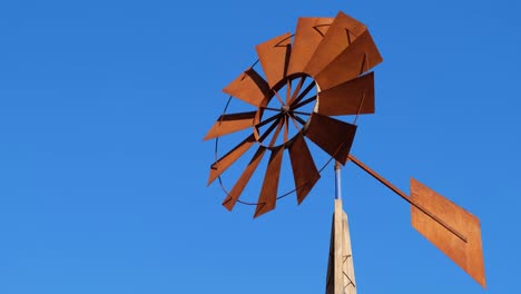 a tower with a fan on an african farm, it rotates with the help of wind force.