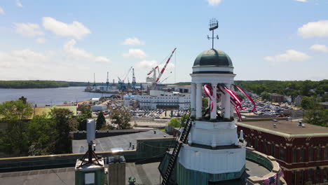 static drone shot of bath city hall, with general dynamics bath iron works in the distance