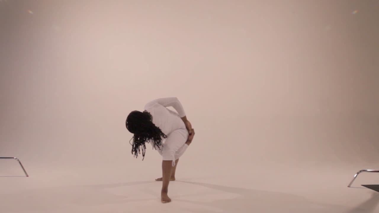 Black yogini moves from a traditional triangle pose to bound triangle pose