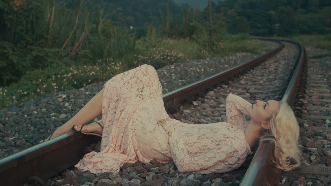 Woman in a lace dress on train tracks