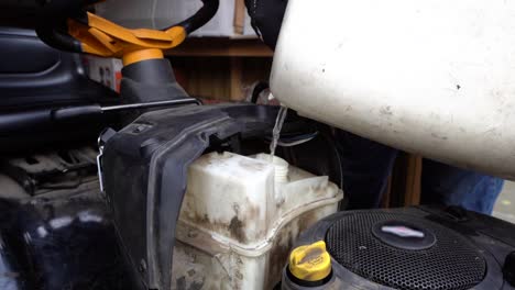 se vierte gasolina a cámara lenta en el tanque de combustible de la cortadora de césped