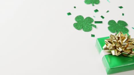 video of st patrick's shamrock leaves and present with copy space on white background