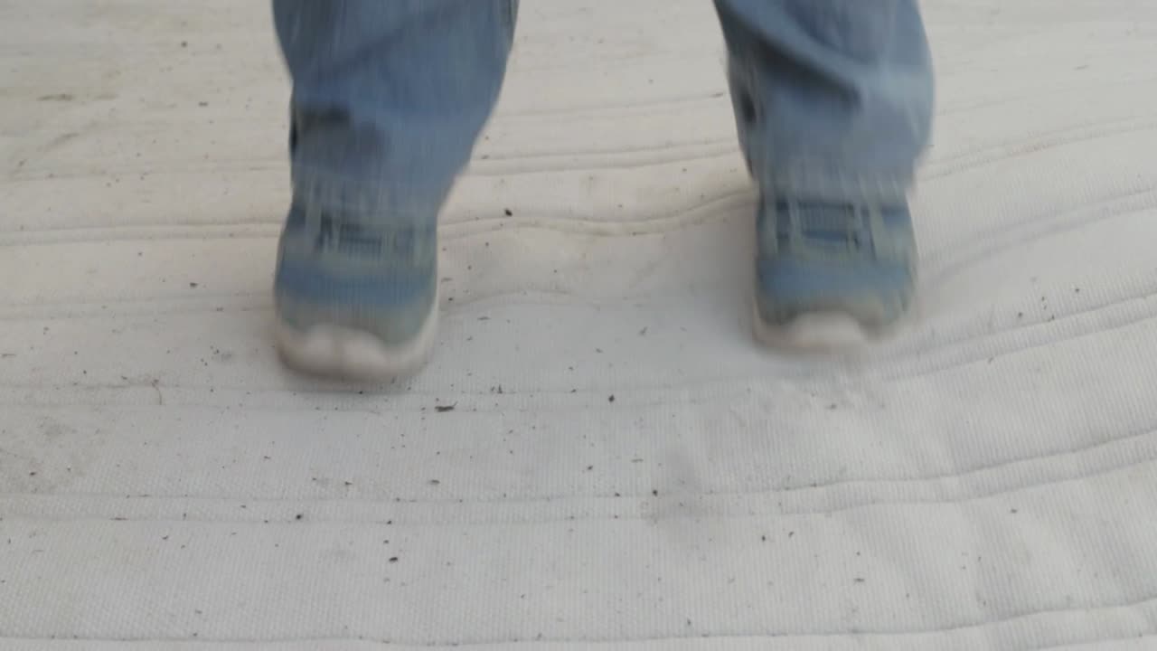 pies saltando arriba y abajo sobre un colchón