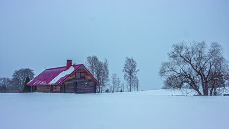 presenciando una nieve de invierno envolviendo una cabaña en un bosque, formando un sudario nevado en todas direcciones esta pintoresca escena es inmortalizada en un video time-lapse, con el sol brillando en el fondo