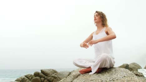 Vista-Frontal-De-Una-Mujer-Caucásica-Realizando-Yoga-En-La-Playa-4k