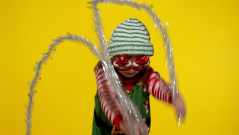 Kid-girl-in-Christmas-elf-Santa-helper-costume-dancing,-fooling-around.-New-Year-holiday-celebration