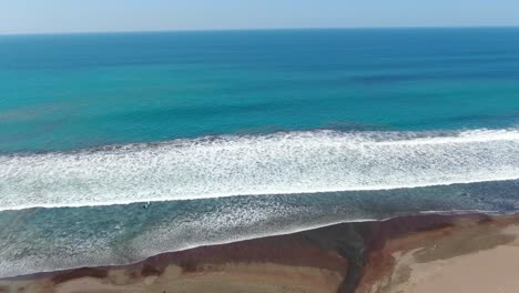 Stranddrohne-Von-Costa-Rica,-Die-An-Einem-Sonnigen-Tag-über-Die-Küste-Und-Ins-Meer-Fliegt,-Mit-Einem-Fluss,-Der-Sich-Zum-Wasser-Des-Pazifischen-Ozeans-öffnet