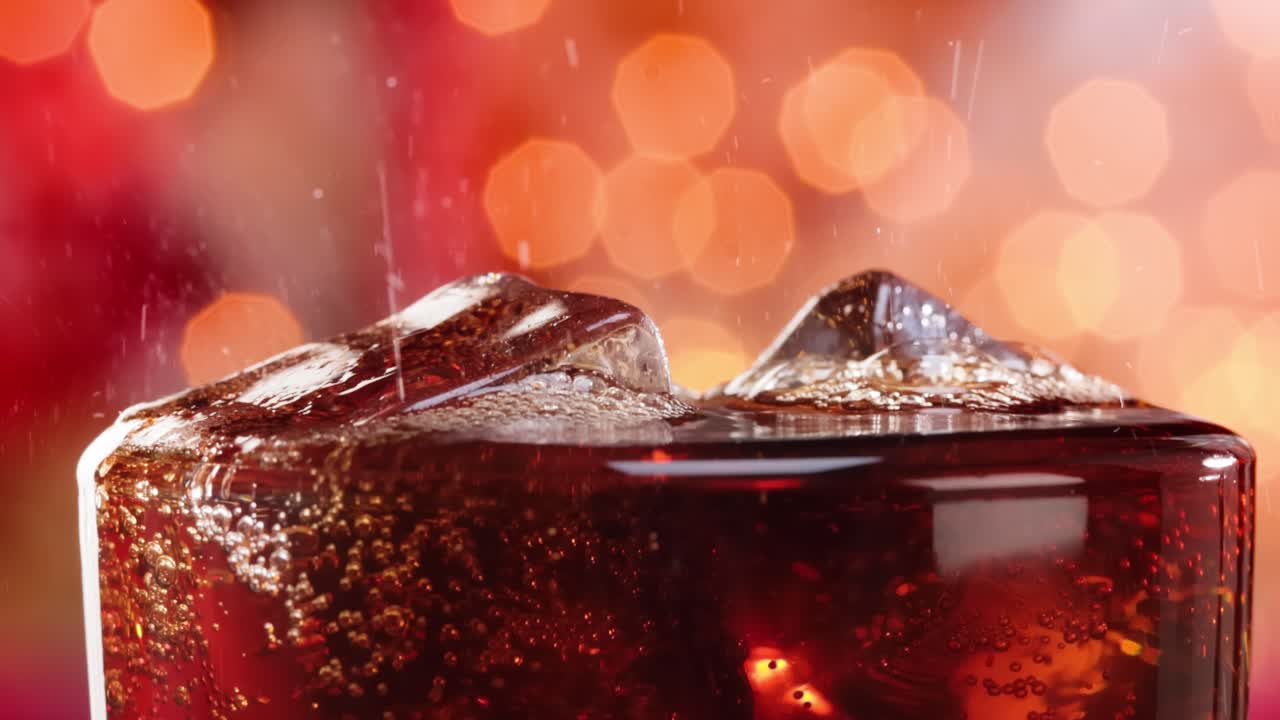 un vaso de cola. cola helada con burbujas salpicando cámara lenta en una luz borrosa, fondo borroso.