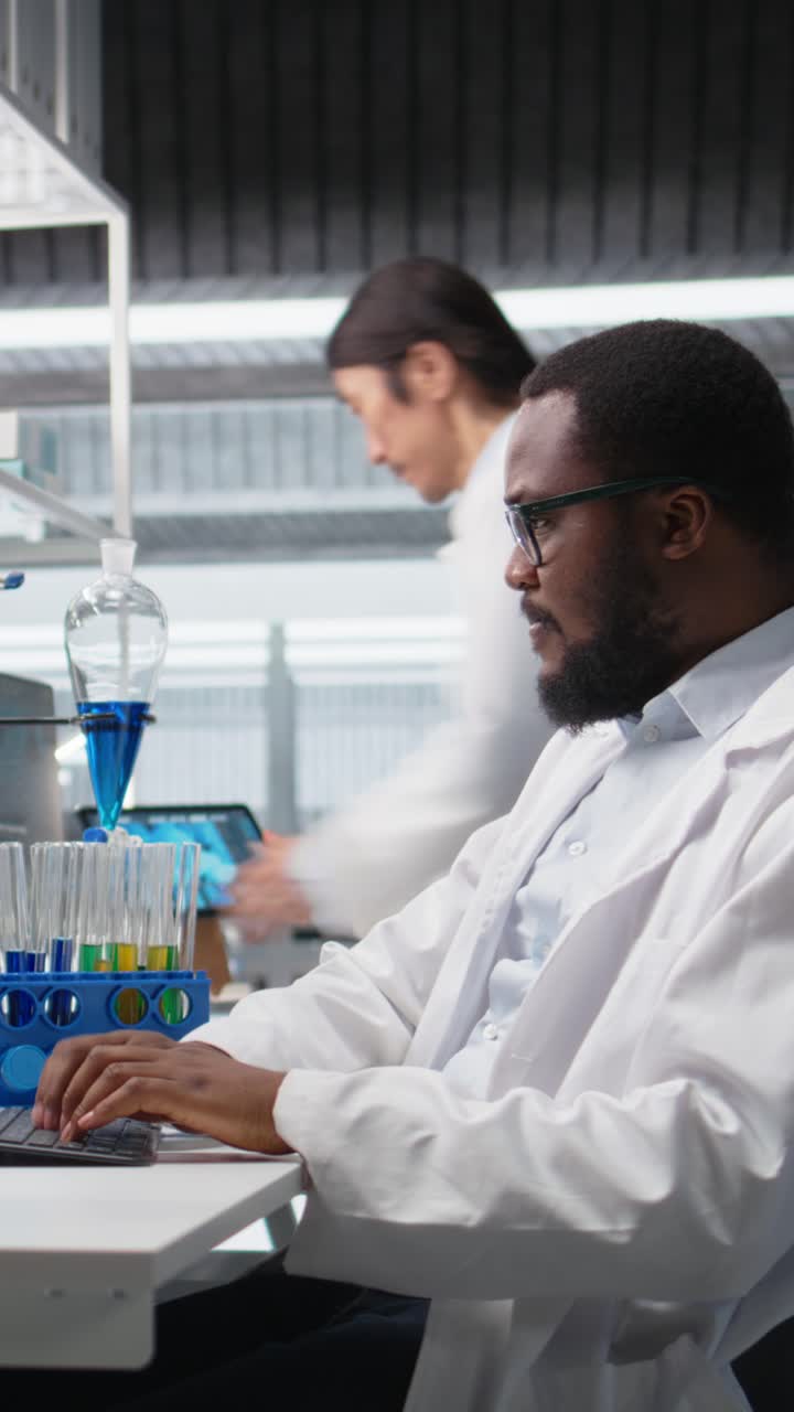 Vertical video Scientist using computer for DNA analysis driving treatment discovery