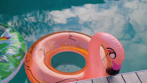 Concepto-De-Viaje-De-Vacaciones-Con-Colchón-Inflable-De-Juguete-Flotante-De-Flamenco-Naranja-En-Una-Piscina-De-Lujo