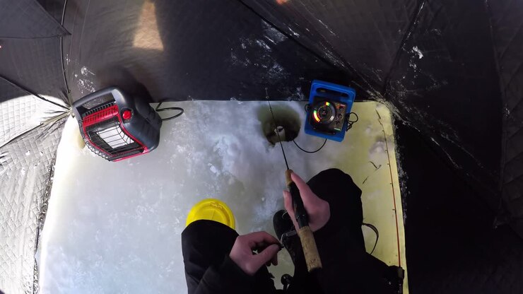 Man preparing for ice fishing in snowy region