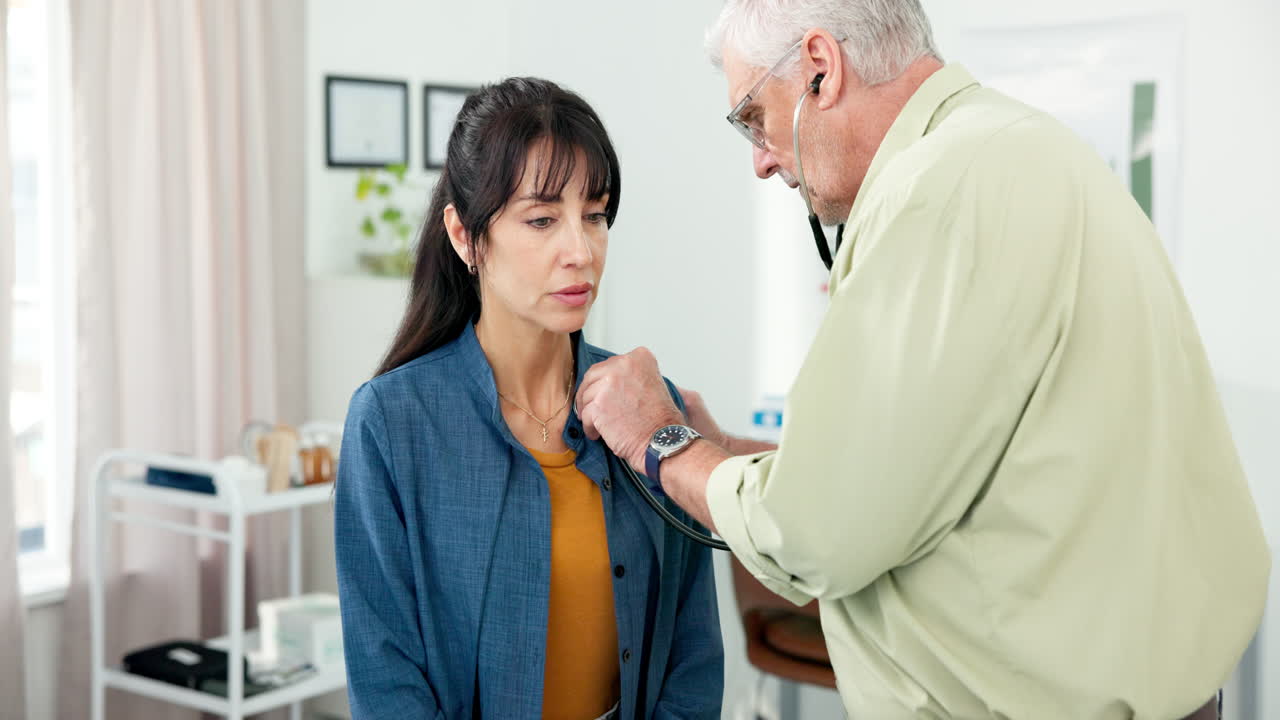 Senior Doctor Examining Female Patient with Stethoscope
