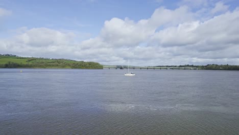 waterford estuary drone reveal of a sailing boat with the barrow railway bridge in the background
