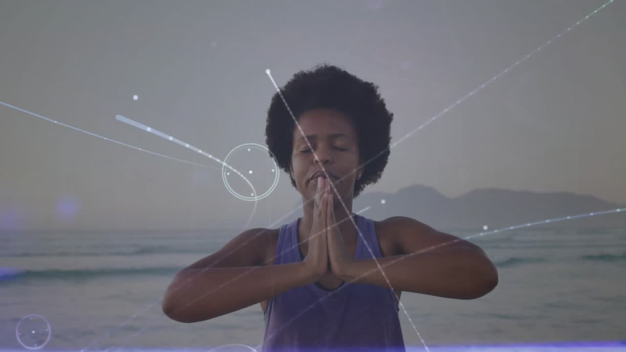 Fechando os olhos, unindo as palmas das mãos, iniciando partículas brilhantes ao redor do iogue meditando no oceano ao entardecer.