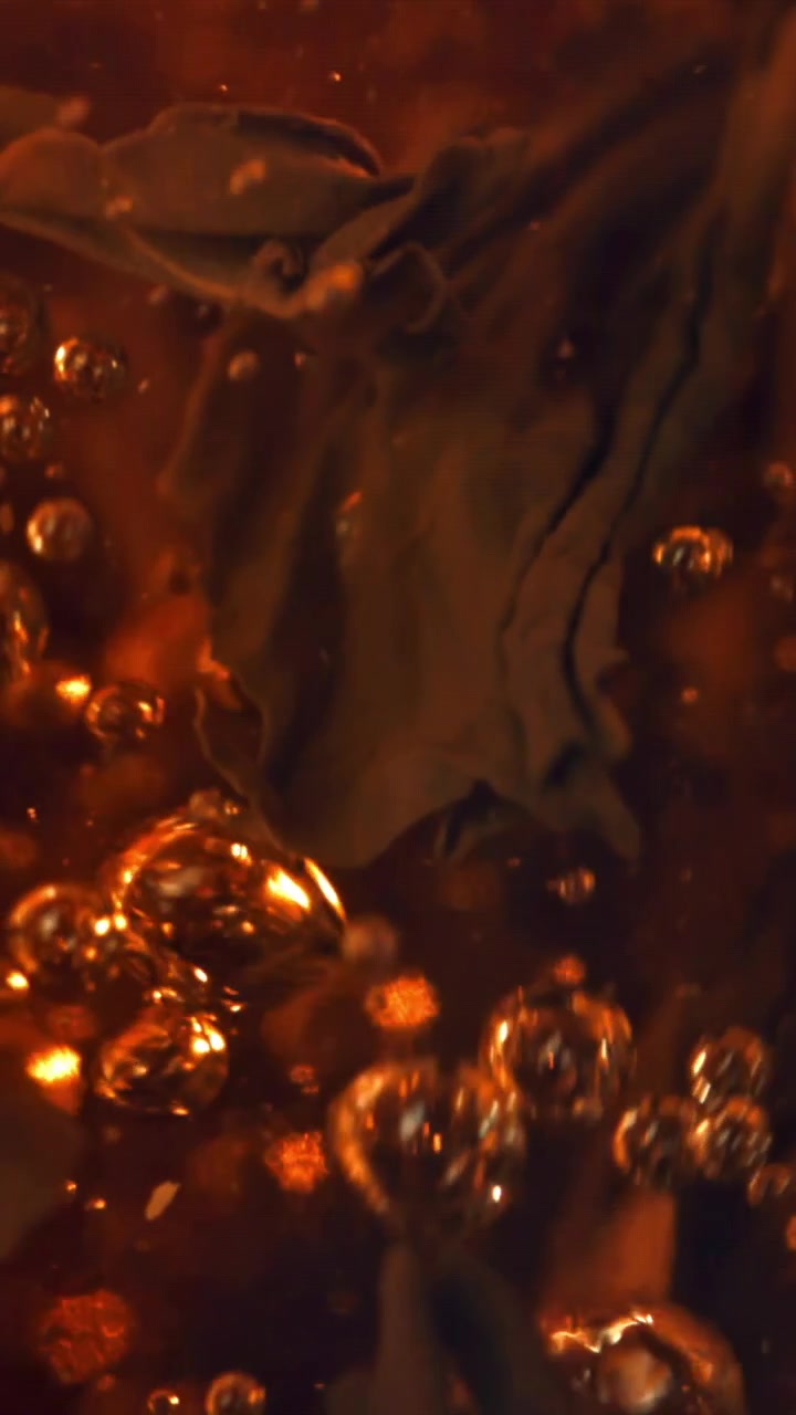 Close-up of Tea Leaves Steeping in Hot Water with Bubbles