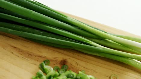 chopped scallions with knife on chopping board 4k