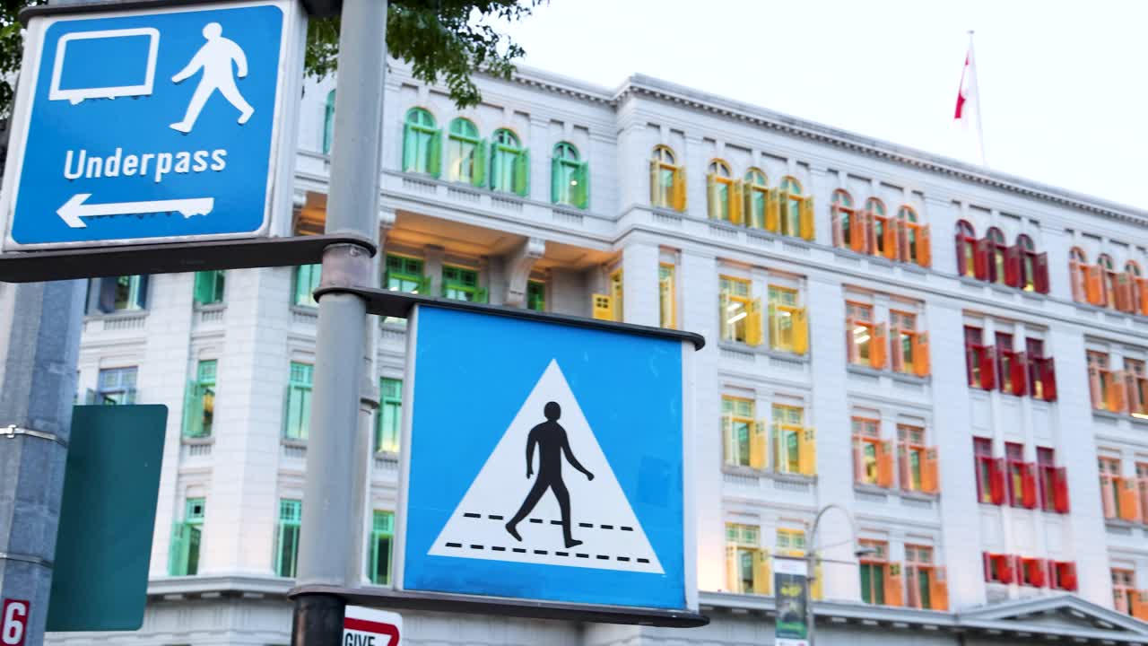 A vibrant historic building with rainbow windows and a pedestrian crossing sign in Singapore