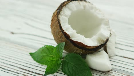 halves of fresh coconut with mint leaves