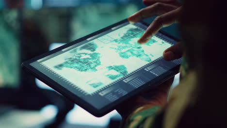 Navy-operations-specialist-examines-a-world-map-with-gps-system-on-his-tablet