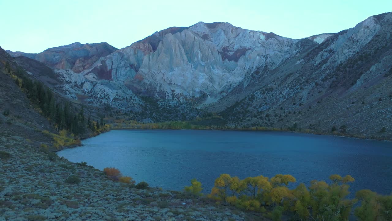 Convict Lake Canyon Trail Mammoth Lakes Mountain aerial drone California autumn fall later afternoon shaded rugged valley peaks yellow Aspen Birch trees clear skies Sierra Nevada range right slide pan