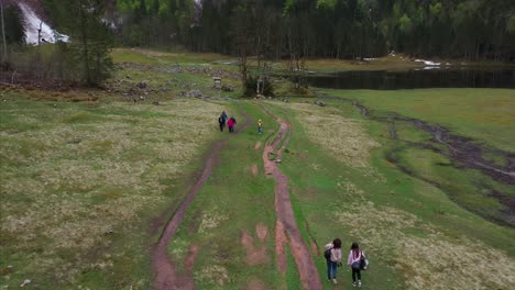hikers on a trail near a mountain lake