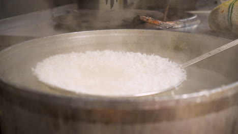 strainer skimmer scoops freshly boiled white basmati rice, slow motion hd