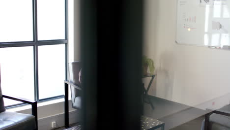 working in office, person sitting on chair next to window and whiteboard