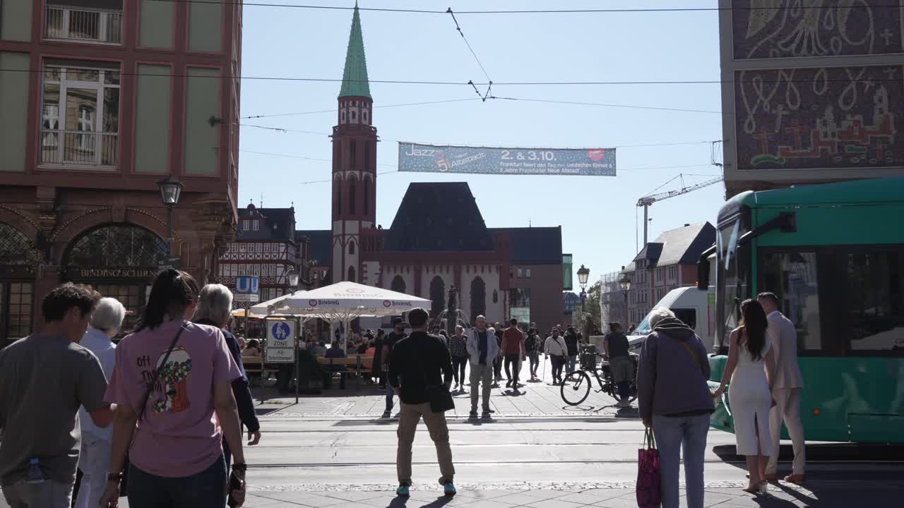Green Tram and People on a City Street in Frankfurt