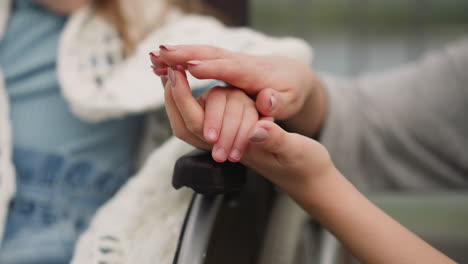 hands of mother stroking small fingers of little daughter