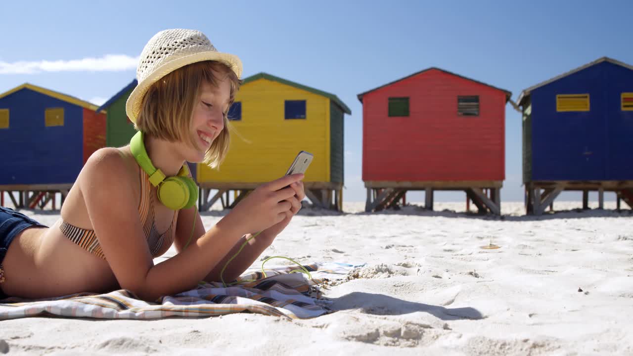chica usando teléfono móvil en la playa 4k