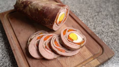 stuffed flank steak cut in slices on wooden cutting board