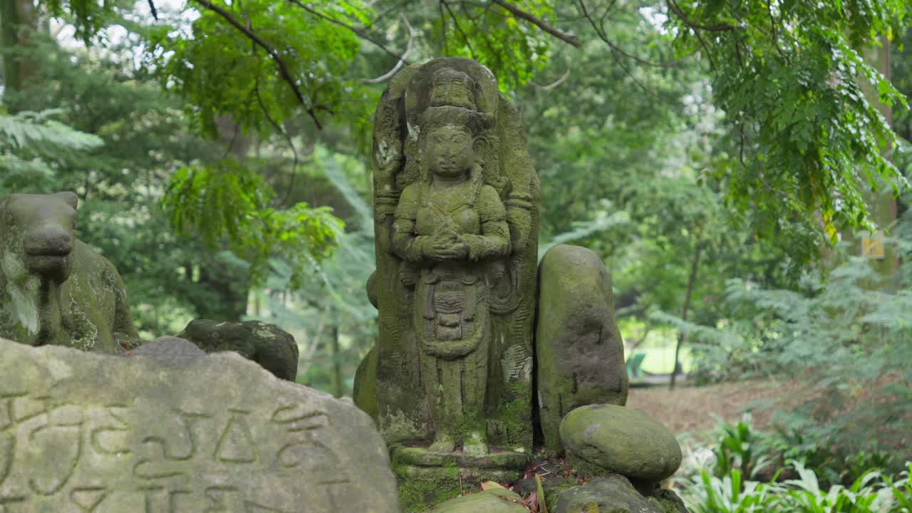 Sacred stone statue of Shiva in middle of the forest and an ancient plaque