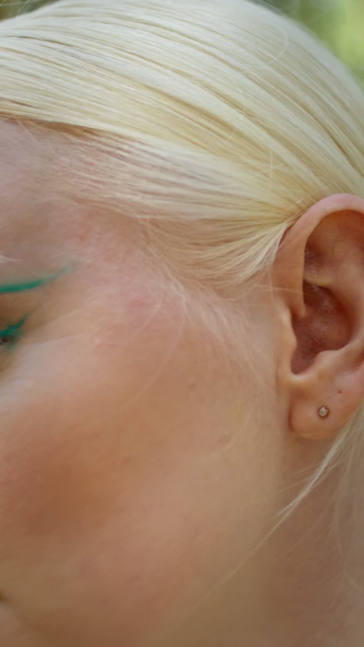 Close-up portrait of a woman with green eyeliner
