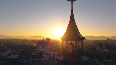 Historic-architecture-clock-tower-illuminated-by-the-sun-at-sunset-drone-shot