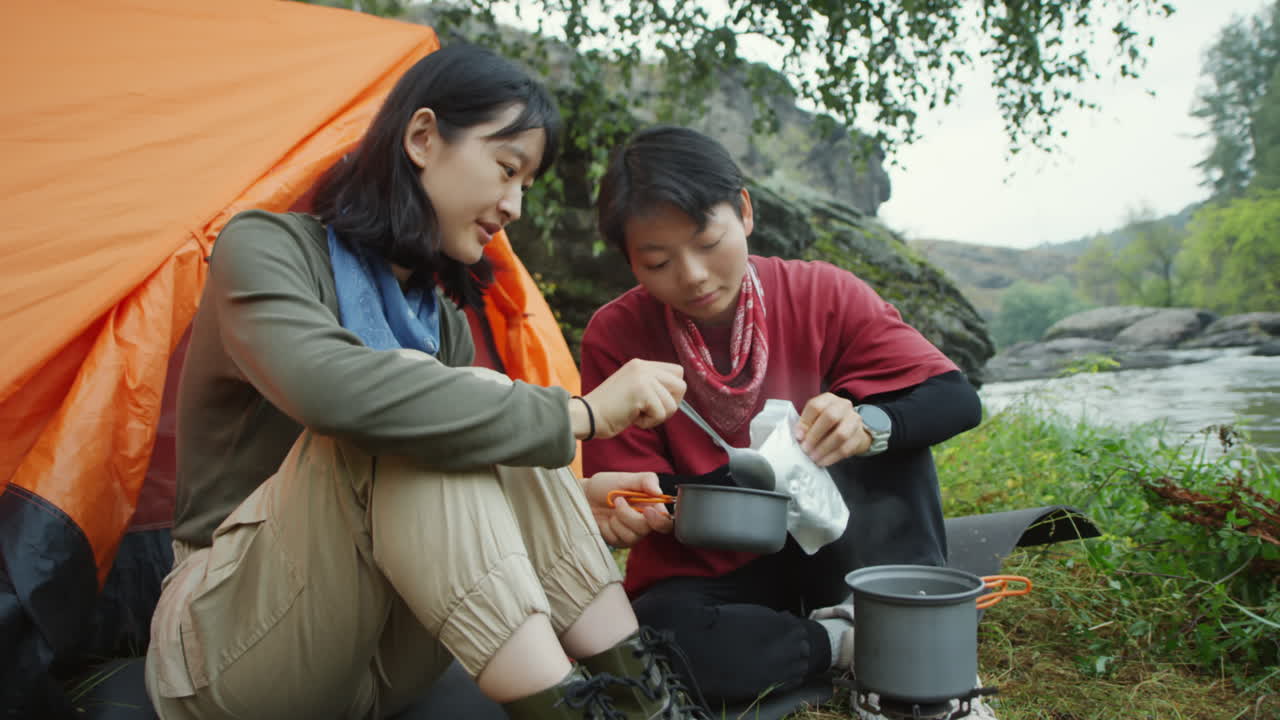 Female Tourists Preparing Dinner at Campsite