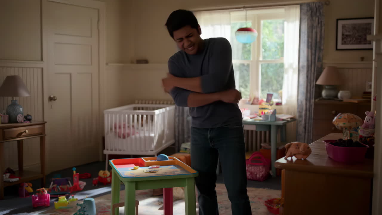 A man experiences back pain in a child's messy room
