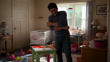 a man experiences back pain in a child's messy room