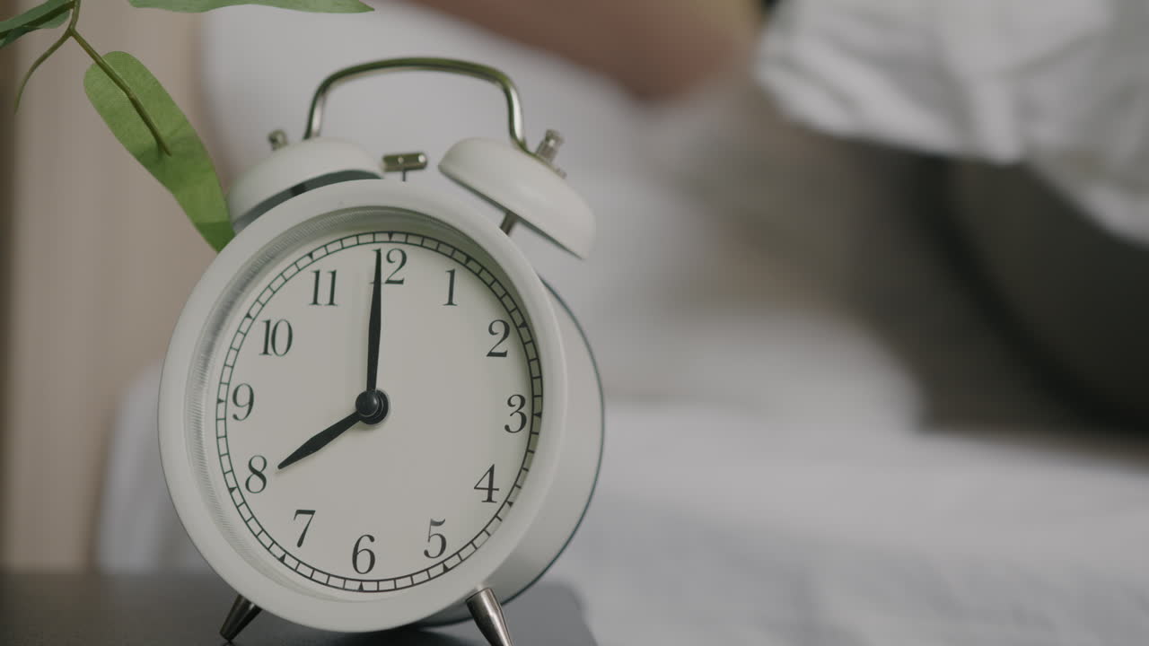 Person waking up with an alarm clock