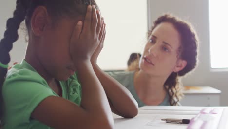 video of caucasian female teacher supporting sad african american girl during lessons