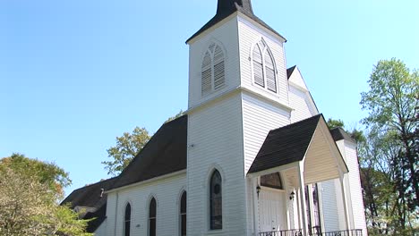 an old rural church stands tall over the country lane in front of it