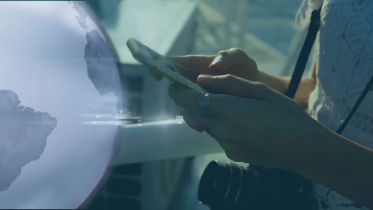 animación de una placa de circuito de computadora y un globo sobre una mujer de raza mixta usando un teléfono inteligente