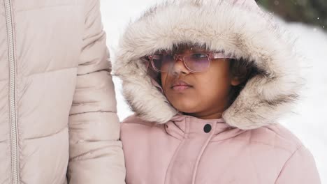 girl in a pink winter coat in the snow