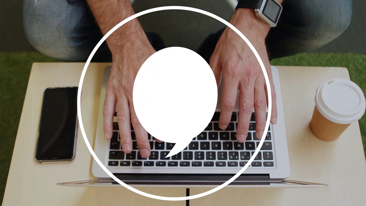 Uomo maturo che digita sul laptop in salotto, con una bolla di chat animata che si forma e pulsa, oscurando i tasti per l'UX.