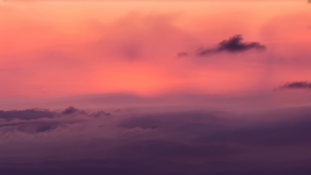 Drifting cloudscape evolving in high-altitude sunset sky as sun dipping causing color shifting