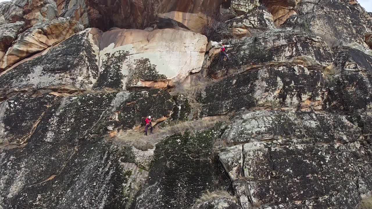 Rock climbers securing the equipment on a massive rock
