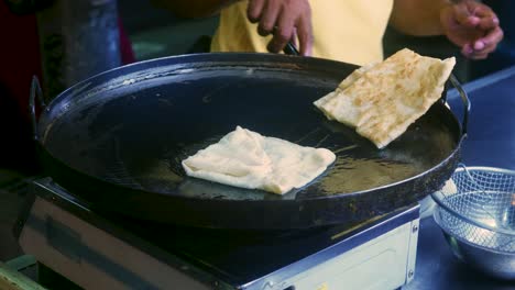 imágenes cinematográficas de cocina de 4k de un chef tailandés preparando un postre tradicional tailandés llamado roti en un mercado callejero en tailandia